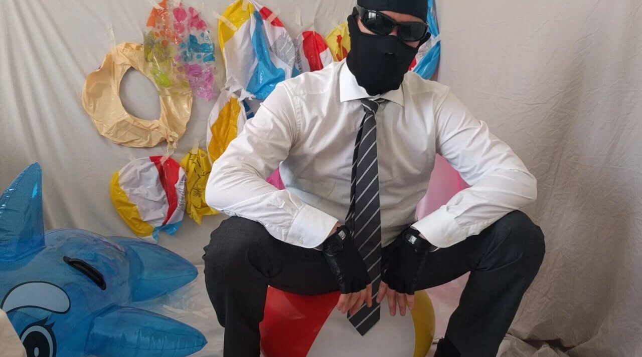 Man sitting on a beach ball looking at the camera | reventemos.com