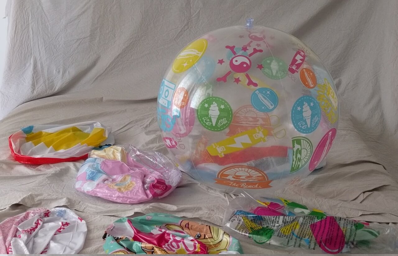 Beach ball on the bed, with other popped balls