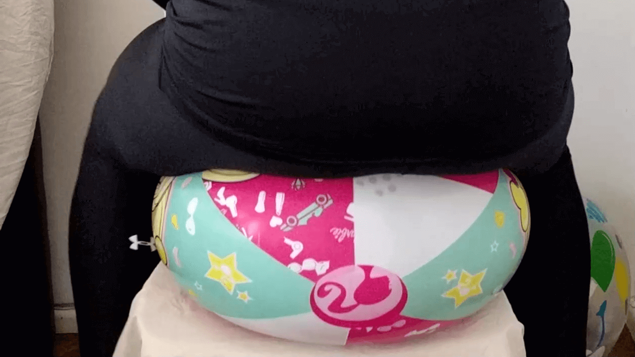 Sit popping a Barbie beach ball on a chair in leggings