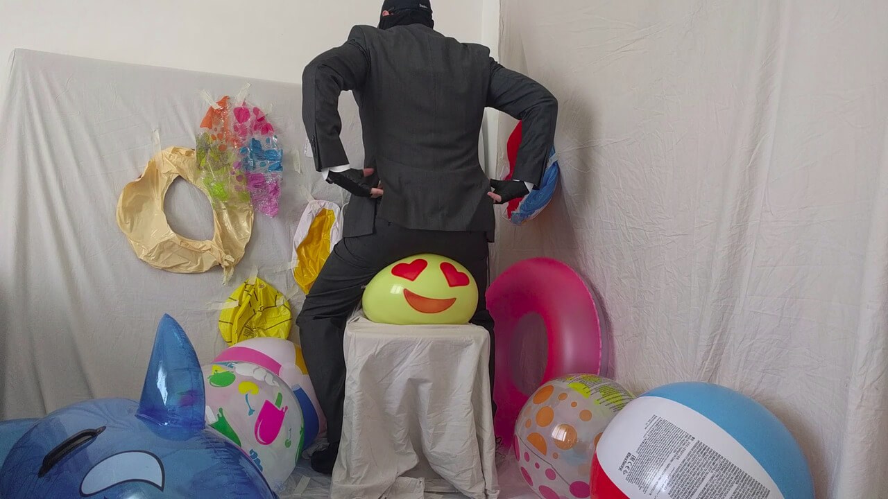 Sit popping a smiley beach ball in a suit after work