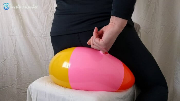 1003. Sit popping small beach balls on a chair in underwear
