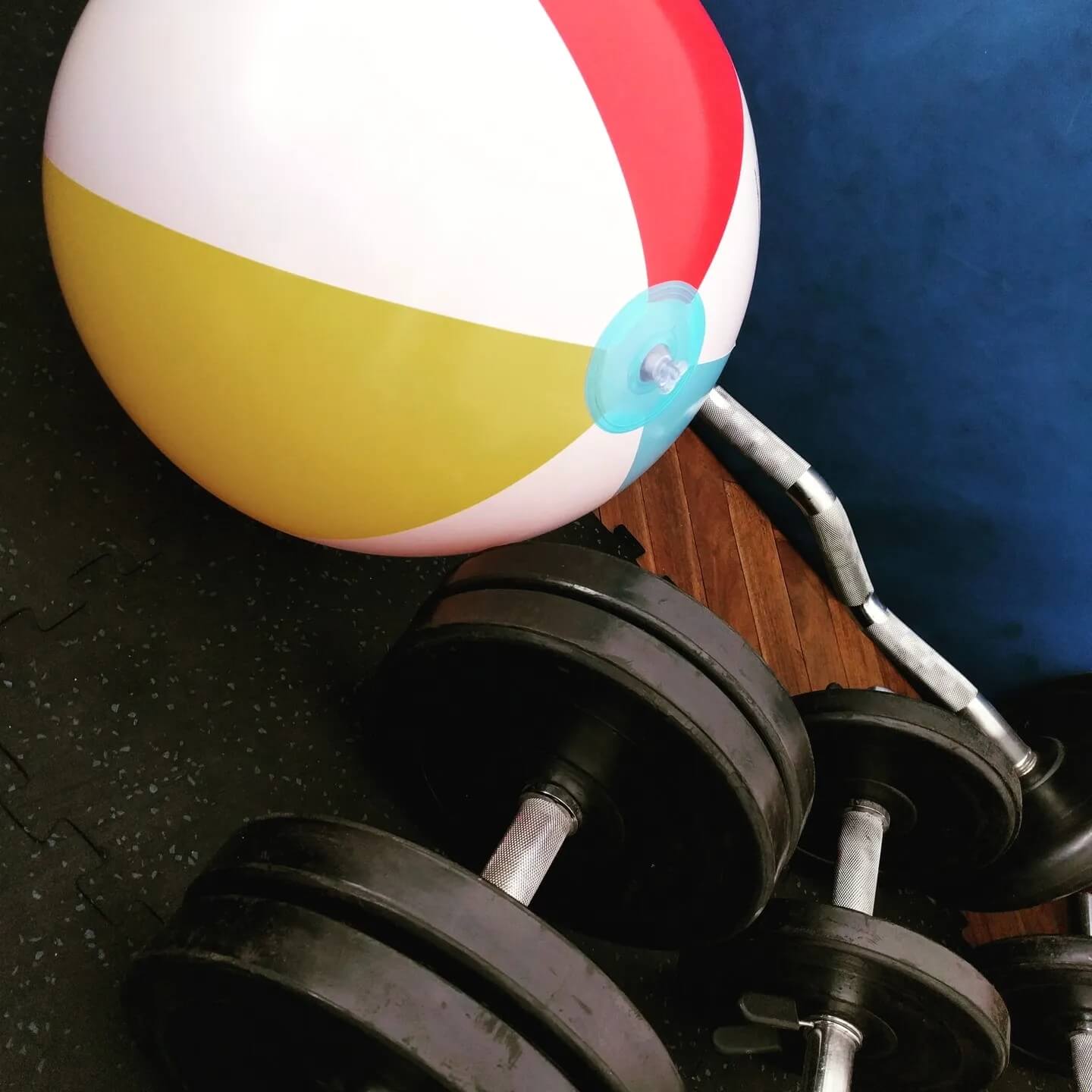 Beach ball with gym stuff and dumbbells