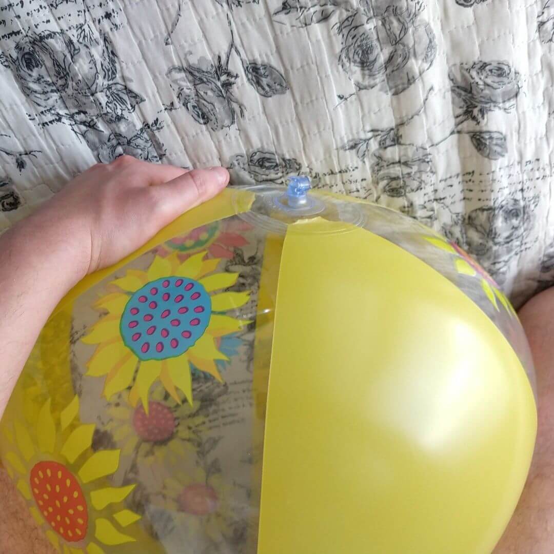 Man on top of a yellow beach ball