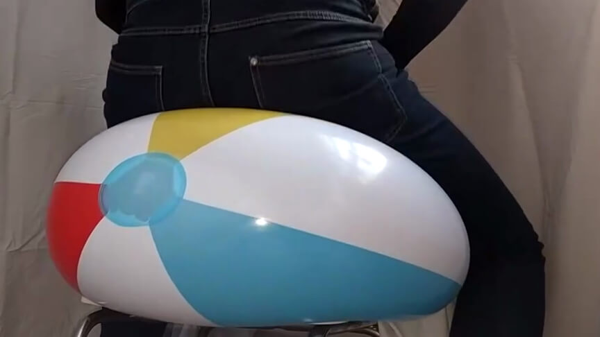 Sit popping 2 beach balls on a chair in jeans